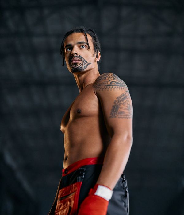 Man performing a powerful strength exercise in a dark, minimalist setting with red energy lines.